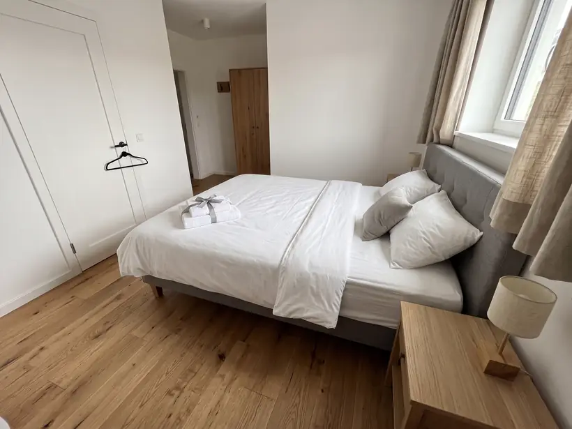 Schlafzimmer einer Ferienwohnung mit frisch bezogenem Bett